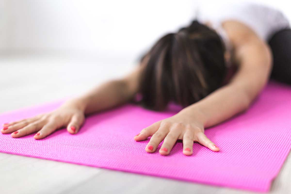 woman stretching on pink yoga mat