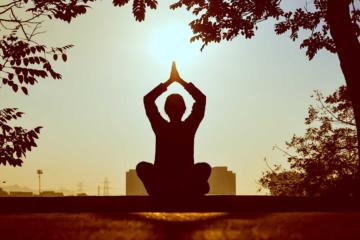 silhouette of person doing yoga at sunset