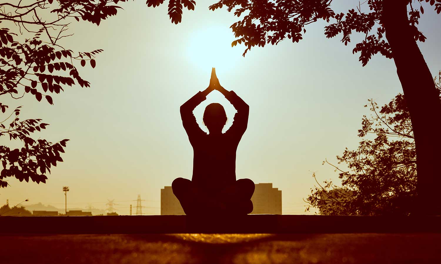 silhouette of person doing yoga at sunset