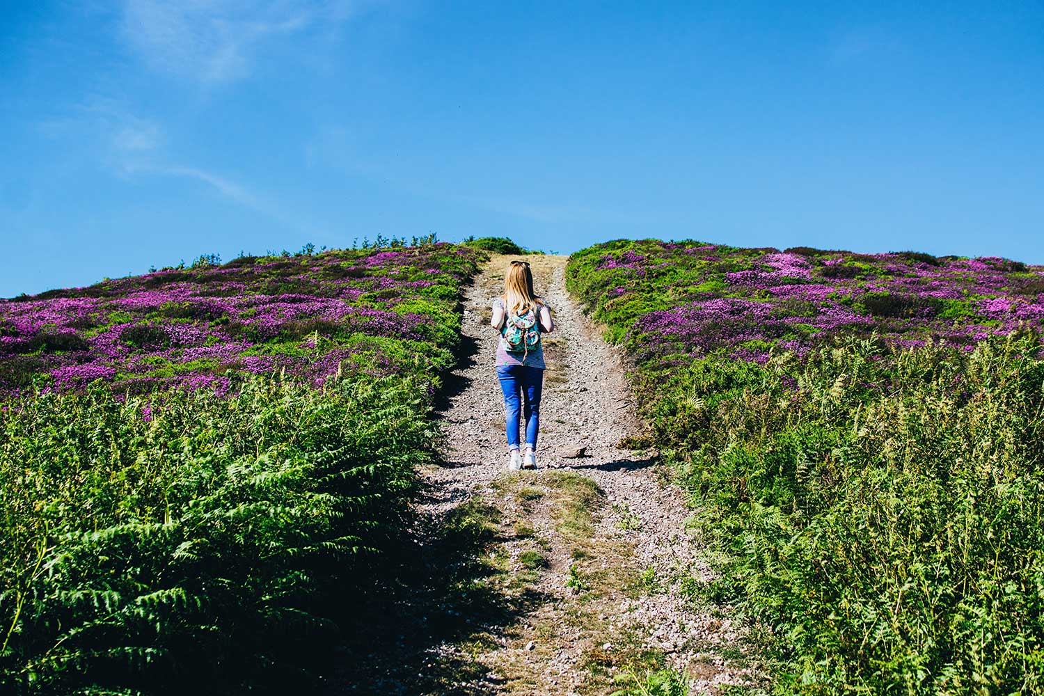 blonde woman walking on trail outdoors