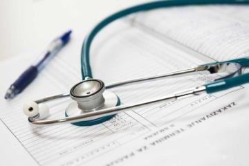 stethoscope and pen sitting on medical chart