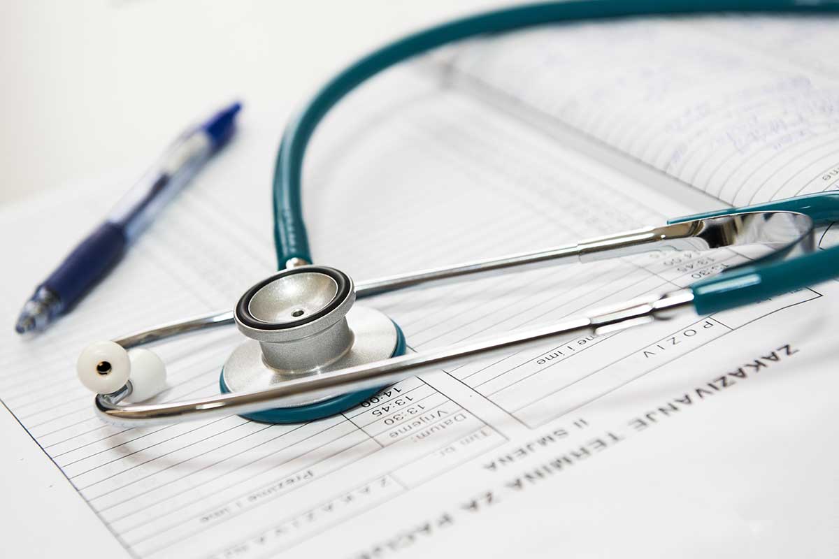 stethoscope and pen sitting on medical chart
