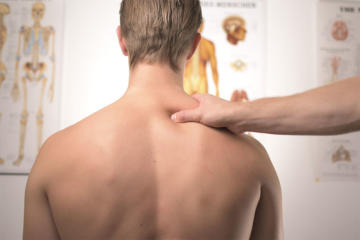 therapist's hand placed on man's right shoulder
